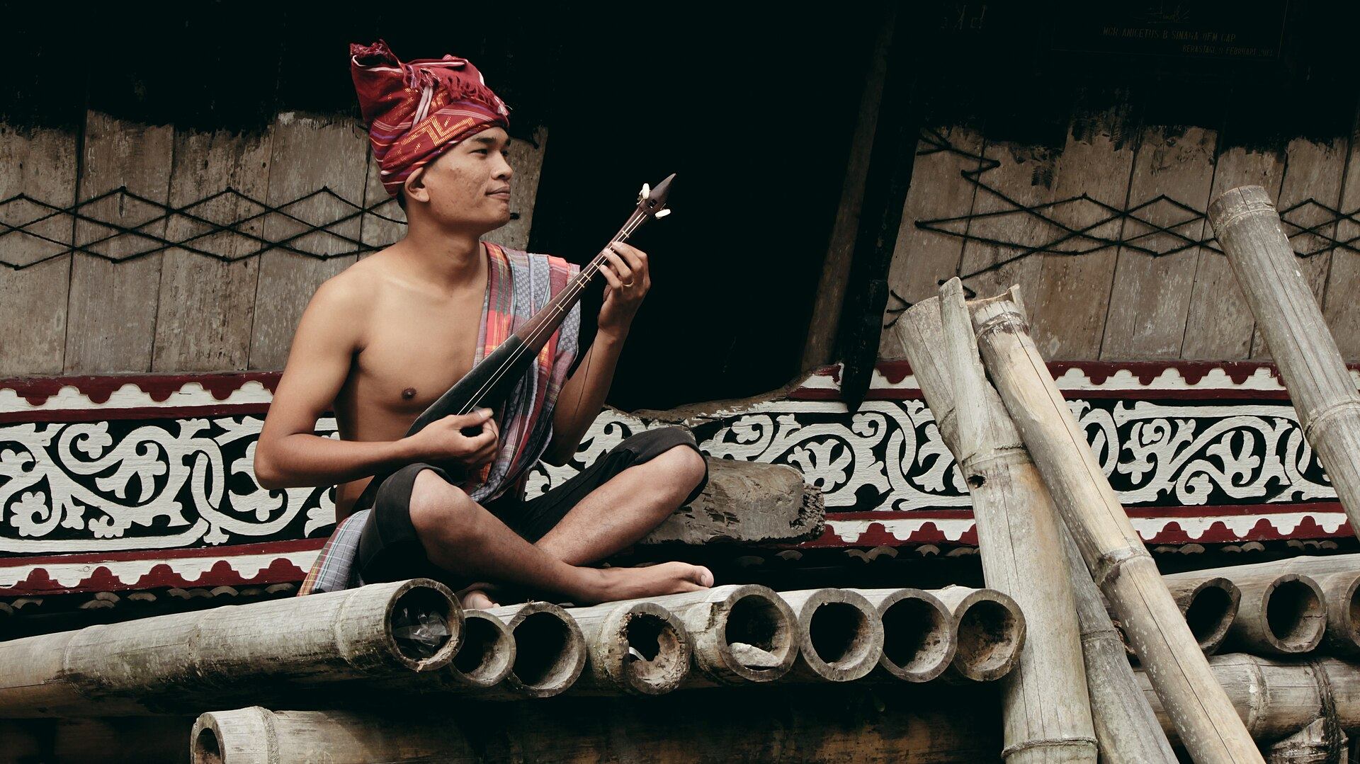 Pemuda Karo memainkan alat musik tradisional Karo